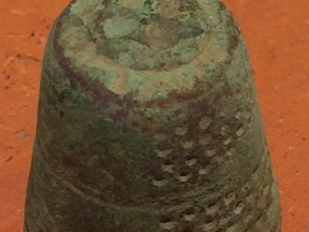 Middeleeuws bronzen handgeputte vingerhoedje met een versiering boven op