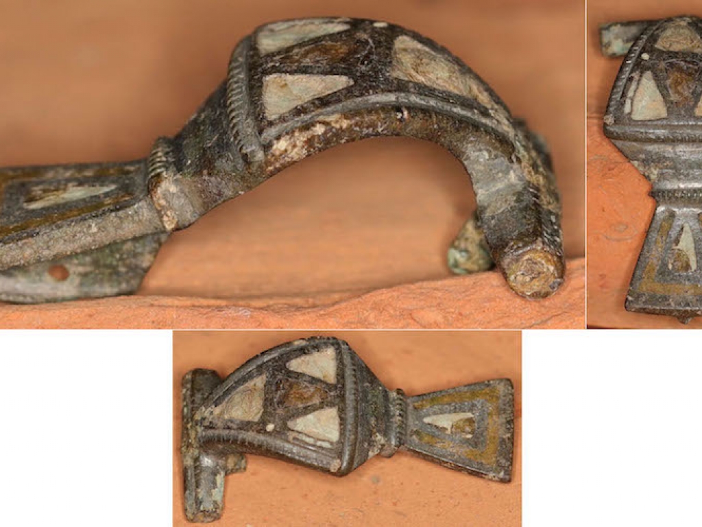 Romeins vertinde hulsscharnierfibula met glaspasta (stukje naald aanwezig)